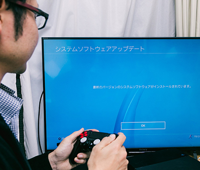 和田さんがゲーム機をチェックしている写真