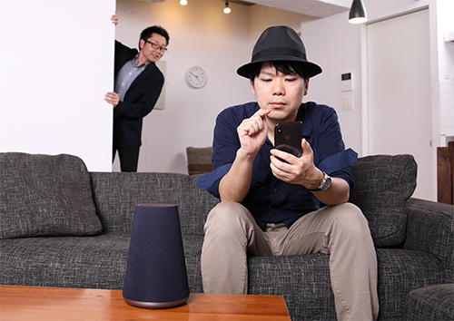 山田井さんがスマホを操作していると、後ろからトレンドマイクロの和田さんが現れた写真