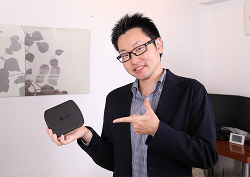 和田さんが「ウイルスバスター for Home Network」を手に持っている写真